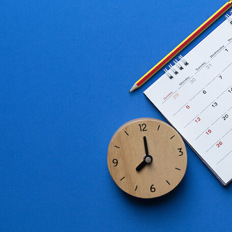Ein Kalender und eine Uhr auf blauem Hintergrund.