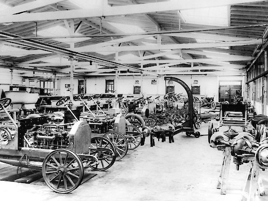 Montagehalle in der viele Automobile stehen (1906)