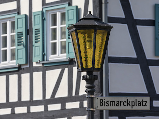 Straßenschild "Bismarckplatz", im Hintergrund ein Fachwerkhaus