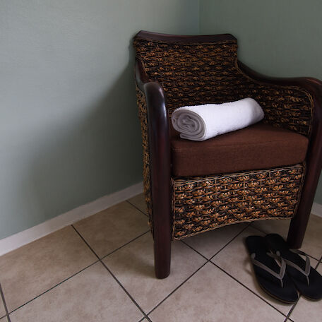 Ein brauner Sessel mit einem Handtuch und Hausschuhen davor