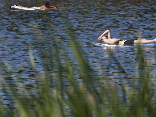 Zwei Badegäste, die sich auf der Luftmatratze auf dem See treiben lassen
