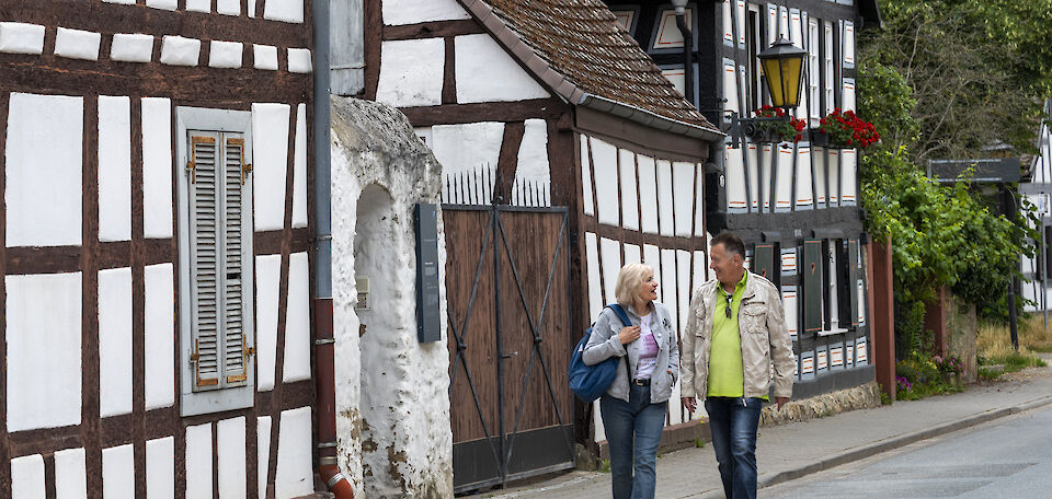 Spaziergänger vor Fachwerkhäusern in Bauschheim