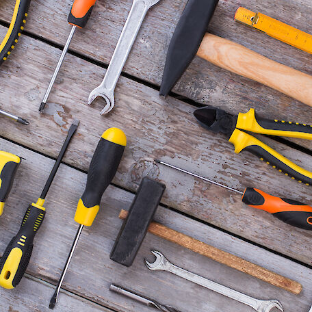 Verschiedene Werkzeuge, die auf einem Holzboden liegen.
