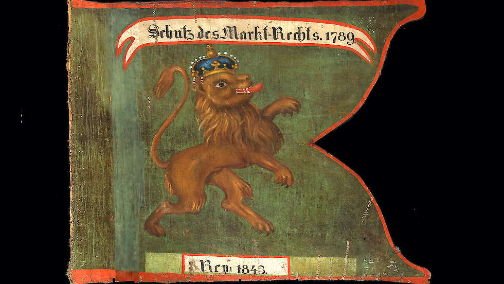 Rüsselsheimer Marktfahne von 1789, die im Jahr 1843 erneuert worden ist. Diese stellt auf grünem Grund einen steigenden, blau gekrönten Löwen dar.