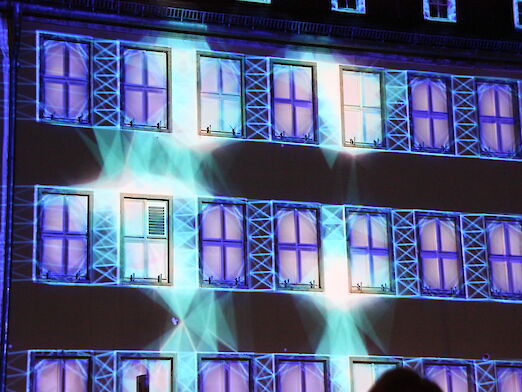 Lichtshow, bei der die Fenster des Rathauses hervorgehoben werden.