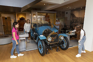 Eine Familie im Museum beim betrachten eines Opel-Oldtimers.