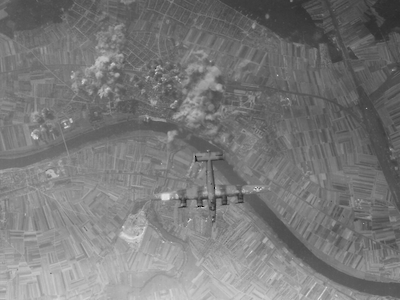 Das Foto zeigt ein Flugzeug über Rüsselsheim nach einem Bombenabwurf auf die Stadt 1944.