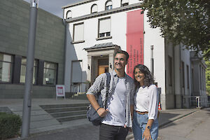 Ein junger Mann und eine junge Frau stehen vor dem Eingang der Opelvillen